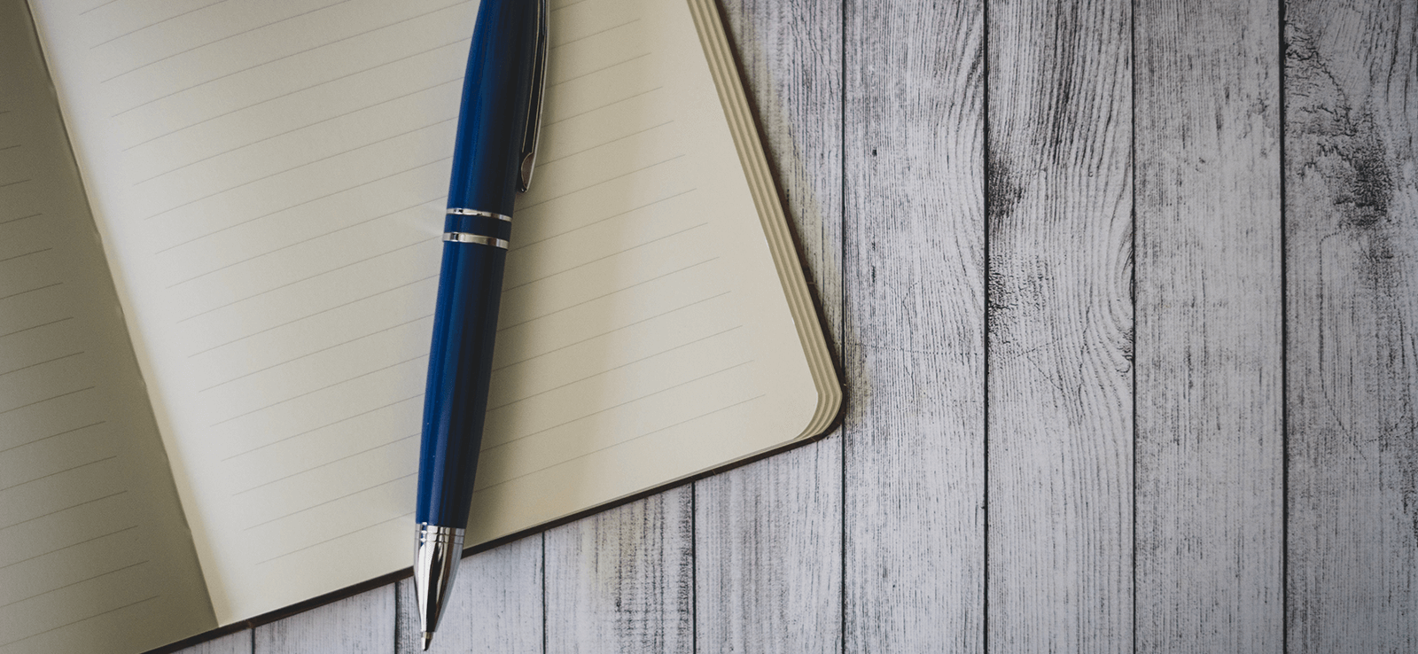 Image of a empty notebook on a wooden surface.